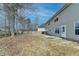 Side view of the home's backyard featuring a concrete patio, spacious lawn, and mature trees at 591 Paper Ridge Ct, Lawrenceville, GA 30046