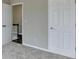 A simple, carpeted bedroom featuring white trim and doors leading to more of the house at 591 Paper Ridge Ct, Lawrenceville, GA 30046