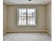 A simple, carpeted bedroom featuring a large window for natural light at 591 Paper Ridge Ct, Lawrenceville, GA 30046