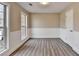 Bright bedroom featuring wood-look floors, wainscoting, and two windows offering ample natural light at 591 Paper Ridge Ct, Lawrenceville, GA 30046