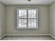 A simple, carpeted bedroom featuring a large window for natural light at 591 Paper Ridge Ct, Lawrenceville, GA 30046