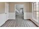 Hallway with wood-look flooring, wainscoting, and view into entryway and stairwell at 591 Paper Ridge Ct, Lawrenceville, GA 30046