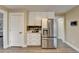 Modern kitchen features stainless steel refrigerator, white cabinets and drawers, and gray backsplash at 591 Paper Ridge Ct, Lawrenceville, GA 30046