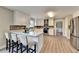 Kitchen with breakfast bar, stainless appliances, white cabinets, gray backsplash and wood flooring at 591 Paper Ridge Ct, Lawrenceville, GA 30046