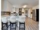Kitchen with breakfast bar, stainless appliances, white cabinets, gray backsplash and wood flooring at 591 Paper Ridge Ct, Lawrenceville, GA 30046