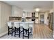 Kitchen with breakfast bar, stainless appliances, white cabinets, gray backsplash and wood flooring at 591 Paper Ridge Ct, Lawrenceville, GA 30046