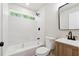 This bathroom features a stylish vanity, a tub with tile surround, and sleek, matte black fixtures at 2081 Verbena Nw St, Atlanta, GA 30314