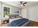 Cozy primary bedroom with a large window, fan, and a comfortable bed with blue accents at 2081 Verbena Nw St, Atlanta, GA 30314