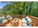 Enjoy outdoor living on this wooden deck with comfortable seating and a view of the surrounding trees at 2081 Verbena Nw St, Atlanta, GA 30314