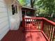 View of the home's exterior featuring a red-stained wooden deck and an adjacent screened-in porch at 3013 Barcelona Way, Conyers, GA 30012