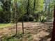 View of the large backyard showing mature trees with sunlight and partial clearing at 3013 Barcelona Way, Conyers, GA 30012