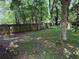 A partially fenced backyard with mature trees and a storage shed, offering a natural and secluded feel at 3013 Barcelona Way, Conyers, GA 30012