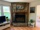 Stone fireplace with wooden mantel and view of the kitchen at 3013 Barcelona Way, Conyers, GA 30012