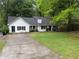 One-story home with white siding, a dark roof, green lawn and driveway at 3013 Barcelona Way, Conyers, GA 30012