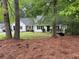 One-story home with white siding, black shutters, framed by trees and lush landscaping at 3013 Barcelona Way, Conyers, GA 30012