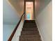 Carpeted staircase with wood railing leads to the upper level at 3013 Barcelona Way, Conyers, GA 30012