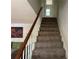 Carpeted stairway with white banister leading to the upper level of the home at 3013 Barcelona Way, Conyers, GA 30012