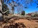 Expansive lot featuring mature trees and an outbuilding set against a clear blue sky at 1828 Kellogg Creek Rd, Acworth, GA 30102
