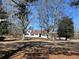View of a white brick home with black shutters on a large, grassy lot framed by mature trees at 1828 Kellogg Creek Rd, Acworth, GA 30102