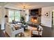 Sunlit living room with a stone fireplace, hardwood floors, and stylish, modern decor at 1828 Kellogg Creek Rd, Acworth, GA 30102