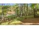 Lush backyard with a lake view, featuring wooden fencing and a staircase leading to a deck at 2210 Hamstead Ct, Suwanee, GA 30024