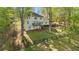 Expansive backyard with lush greenery, wooden fencing, and a charming two-story home nestled among the trees at 2210 Hamstead Ct, Suwanee, GA 30024