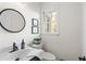 Cozy half bathroom has a sink, toilet, mirror and window providing natural light at 2210 Hamstead Ct, Suwanee, GA 30024