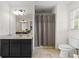Bathroom features single vanity with dark cabinets, toilet, and shower with curtain at 2210 Hamstead Ct, Suwanee, GA 30024