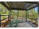 Wooden deck with a trellis and black railing, nestled in a lush, wooded backyard at 2210 Hamstead Ct, Suwanee, GA 30024
