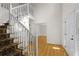 Welcoming foyer featuring hardwood floors, a staircase with white railings, and an open doorway to adjoining room at 2210 Hamstead Ct, Suwanee, GA 30024