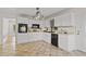 Well-lit kitchen features white cabinets, black appliances, and stylish tile floors at 2210 Hamstead Ct, Suwanee, GA 30024
