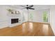 Bright living room features hardwood floors, a ceiling fan, and a charming white painted brick fireplace at 2210 Hamstead Ct, Suwanee, GA 30024