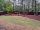 A beautifully landscaped backyard with lush green grass, garden beds, and a wood fence at 3622 Foxtrot Nw Trl, Kennesaw, GA 30144