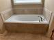 Bathroom featuring a large soaking tub with tile surround and tiled floors at 3622 Foxtrot Nw Trl, Kennesaw, GA 30144