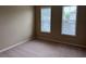 A carpeted bedroom with two windows and neutral paint provides a bright and comfortable space at 3622 Foxtrot Nw Trl, Kennesaw, GA 30144
