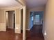 View of a beige hallway leading to a living room with dark wood floors and neutral paint at 3622 Foxtrot Nw Trl, Kennesaw, GA 30144
