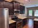 Kitchen with stainless steel appliances, granite countertops, and dark cabinets at 3622 Foxtrot Nw Trl, Kennesaw, GA 30144