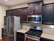 Modern kitchen with stainless steel appliances, granite countertops, and dark cabinets at 3622 Foxtrot Nw Trl, Kennesaw, GA 30144