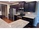 Modern kitchen with stainless steel appliances, granite countertops, and dark cabinets at 3622 Foxtrot Nw Trl, Kennesaw, GA 30144