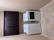 A well-organized laundry room with a stacked washer and dryer and dark wood storage cabinets at 3622 Foxtrot Nw Trl, Kennesaw, GA 30144