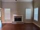 Living room featuring hardwood floors, brick fireplace, and large windows creating a warm space at 3622 Foxtrot Nw Trl, Kennesaw, GA 30144