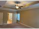 Spacious main bedroom with tray ceiling, fan, carpet, and attached bathroom with a soaking tub at 3622 Foxtrot Nw Trl, Kennesaw, GA 30144