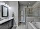 Well-lit bathroom featuring double sinks, vanity, glass enclosed shower, and a tub at 4007 Dunwoody Trce, Atlanta, GA 30338