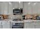 Kitchen with stainless steel appliances, granite countertops, and tiled backsplash at 4007 Dunwoody Trce, Atlanta, GA 30338
