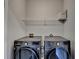 Modern laundry room featuring front-load washer and dryer with overhead shelving at 4007 Dunwoody Trce, Atlanta, GA 30338