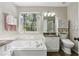 This well-lit bathroom features a tub, shower, marble floors, and storage space at 5845 Shannon Dr, Cumming, GA 30040