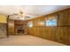 Finished basement featuring paneled walls, carpeted floors, and a brick fireplace at 2198 Kings Forest Se Dr, Conyers, GA 30013