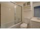 Bathroom featuring a tub with sliding glass doors, toilet, and cabinet storage at 2198 Kings Forest Se Dr, Conyers, GA 30013
