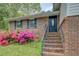 A charming brick home is accentuated with pink azaleas and brick stairs leading to the front door at 2198 Kings Forest Se Dr, Conyers, GA 30013
