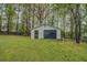 Detached garage in backyard featuring a roll up garage door and side door at 2198 Kings Forest Se Dr, Conyers, GA 30013